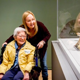 A woman in a wheelchair looking at a sculpture