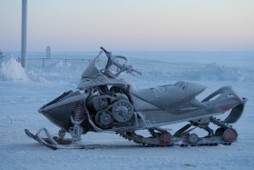 Blue tinted photo of a ski-doo covered in frost 