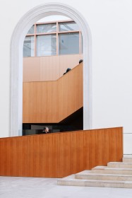 image of Walker Court in the Art Gallery of Ontario, of an archway, wooden ramp and stone stairs. Artist jes sachse's head is visible just above the ramp.