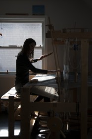 Silhouette of woman weaving