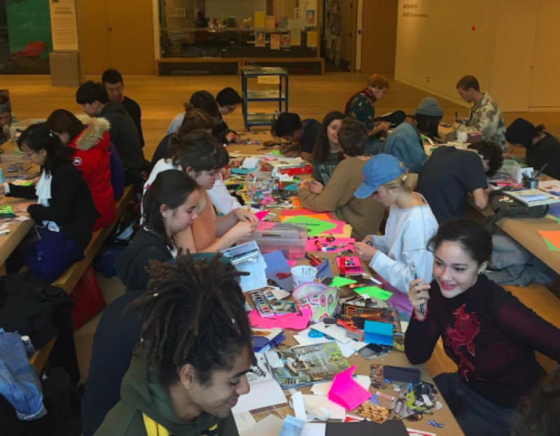 youth at long tables making postcards