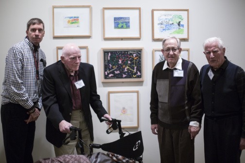elderly visitors with walker in front of art works