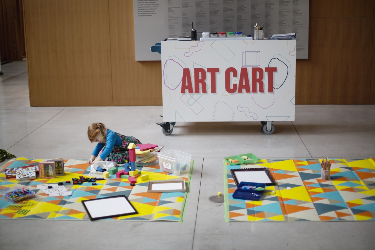 A child plays with art materials on the floor of the AGO