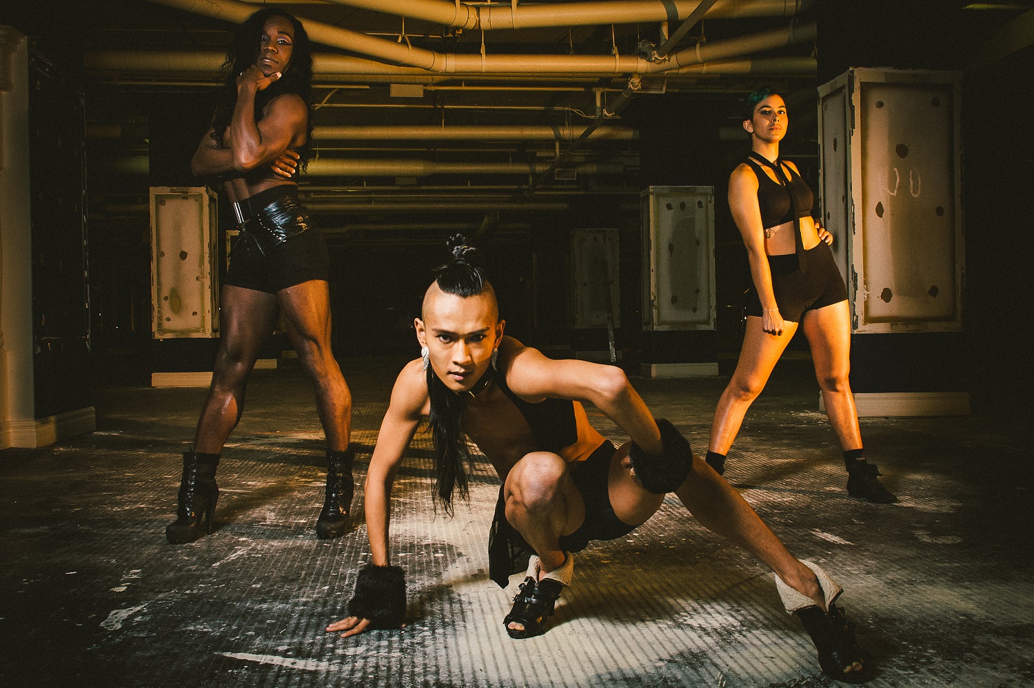 Dancers of ILL NANA/DiverseCity Dance Company pose in an industrial space.