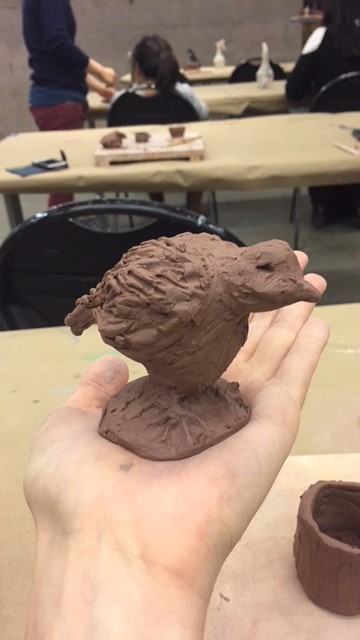 A clay bird rests on a hand