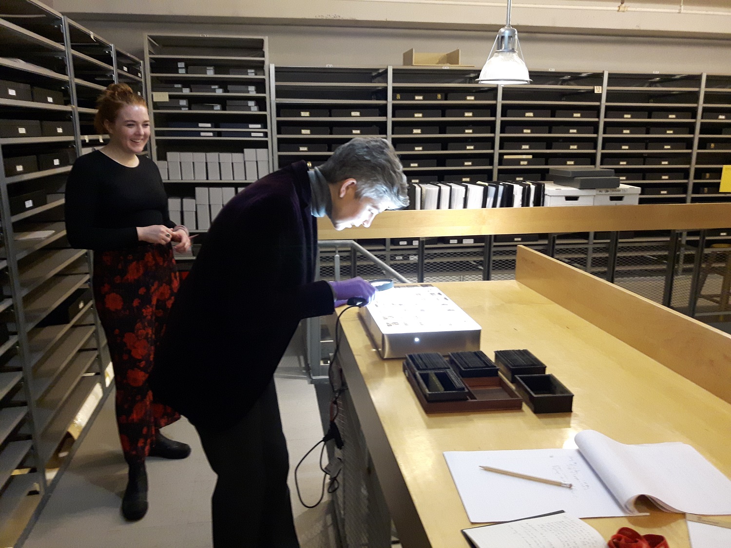 Curator Sophie Hackett and photography intern Emily Miller examining the slides