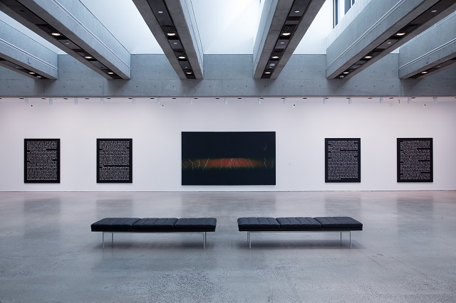Four large canvases with script with an image of a storm in the center