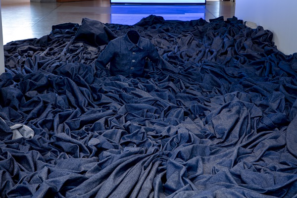 Sculpture of denim shirt surrounded by denim water