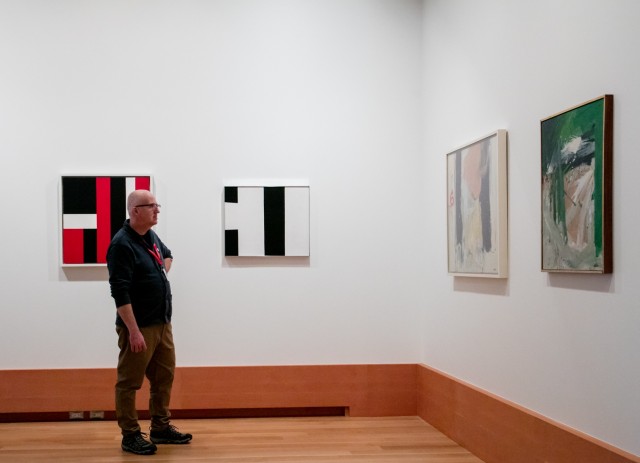 man looking at paintings
