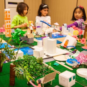 kids in front of a paper city model
