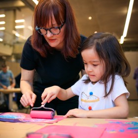 child painting with adult
