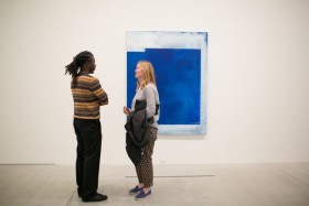 two people talking infront of painting
