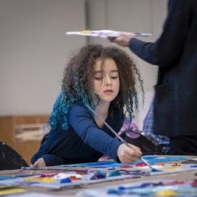 child using a brush to paint