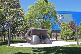 Two large forms, sculpture by henry moore in grange park surrounded by trees and blue skies