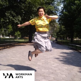 Amanda jumping in a park and moving their arms and legs