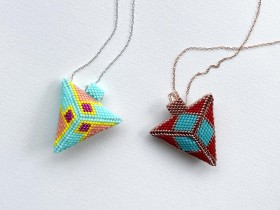two beaded pyramid-shaped pendants on fine chains. Pendant on the left is aqua, peach and yellow; on the right red with teal. 