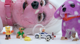 Marissa Sean Cruz dressed as a pink dog lying down surrounded by animal figurines