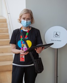 Photo of a slim, blonde lady holding a clipboard and wearing a mask
