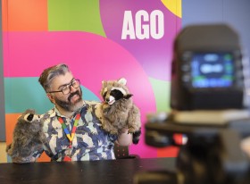 an ago educator interacts with puppets in front of a camera