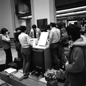 people gathered around a xerography printer in AGO's walker court in the 1970s