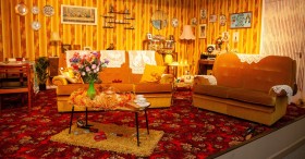 colour photo of a 1970s living room in warm colours of yellow, gold, red, orange