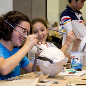 child painting paper mache object during art lab camp