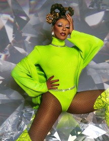 Tynomi Banks wearing lime green body suit and fishnet stockings