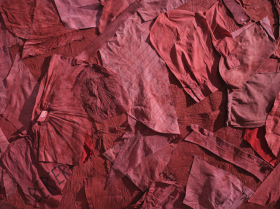 Red fabric of various shades and tones spread out upon a flat surface