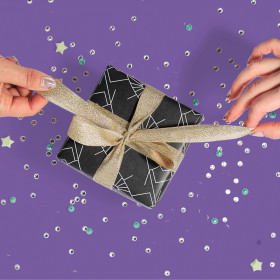 two hands tying on bow on a gift box with a stylized background