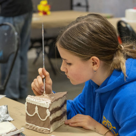 child painting sculpture of a cake slice