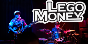Two young male muscians wearing baseballs caps and sunglasseses playing guitar and drums.