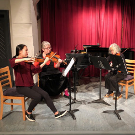 Four women playing music in a quarter