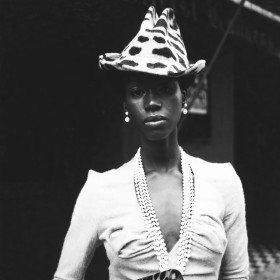 Black and white photograph of a stylish woman in a hat