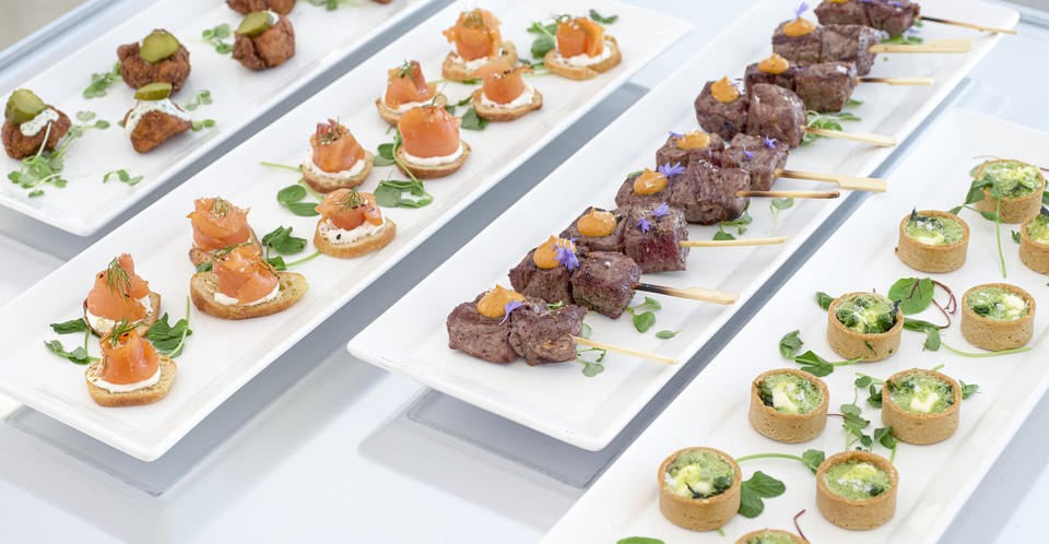 canapés on white long rectangular platters