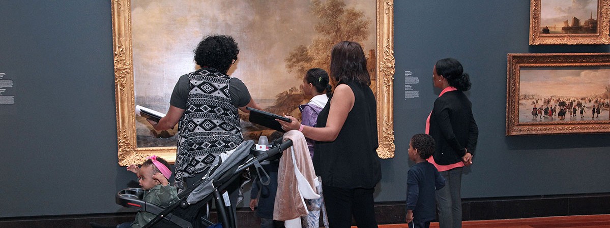 people with child in stroller looking at a painting in gallery