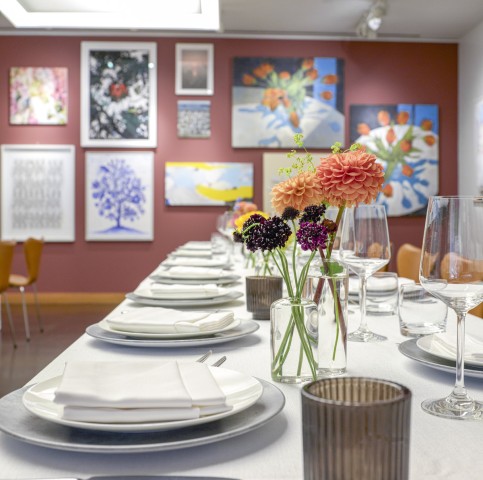 long table set for meal in Bistro Red Room, flowers in vases on table