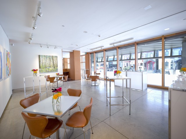 high and low tables with flowers in vases in AGO Art Social room, windows to Dundas St in the background