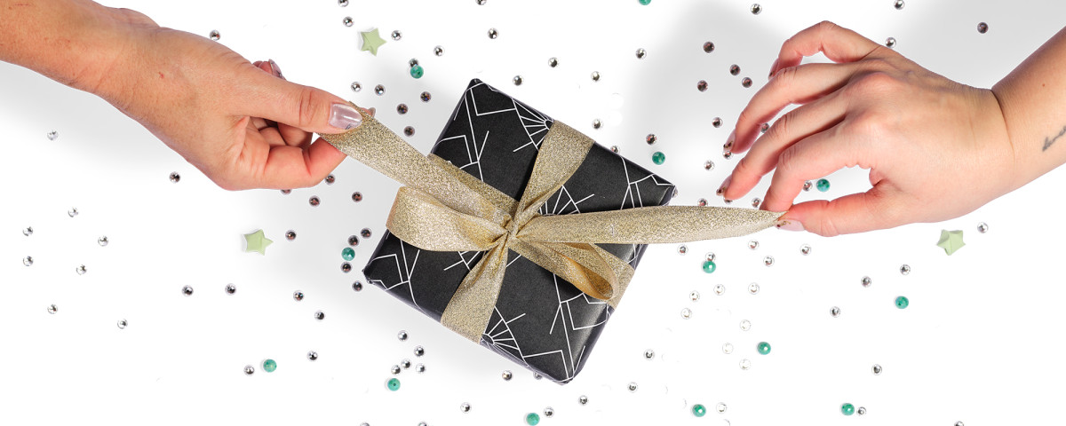 gift wrapped bow being pulled loose by two hands