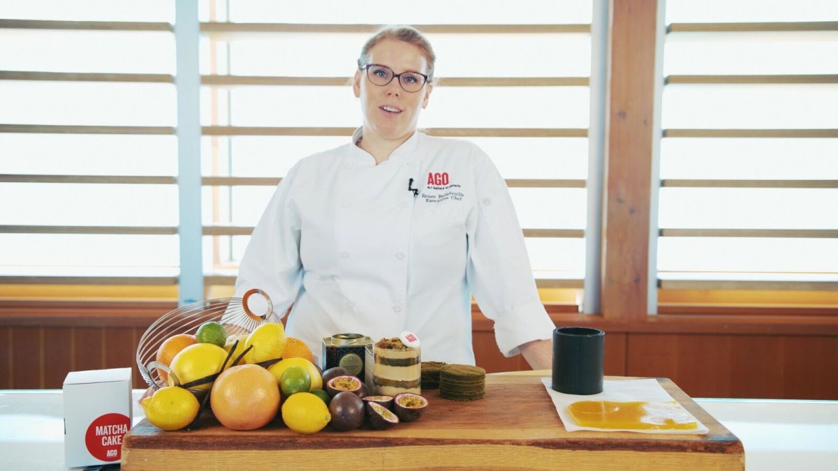 AGO Executive Chef Renee Bellefeuille prepares a matcha cake at a table with a pile of citrus fruit, tea, and a cake.