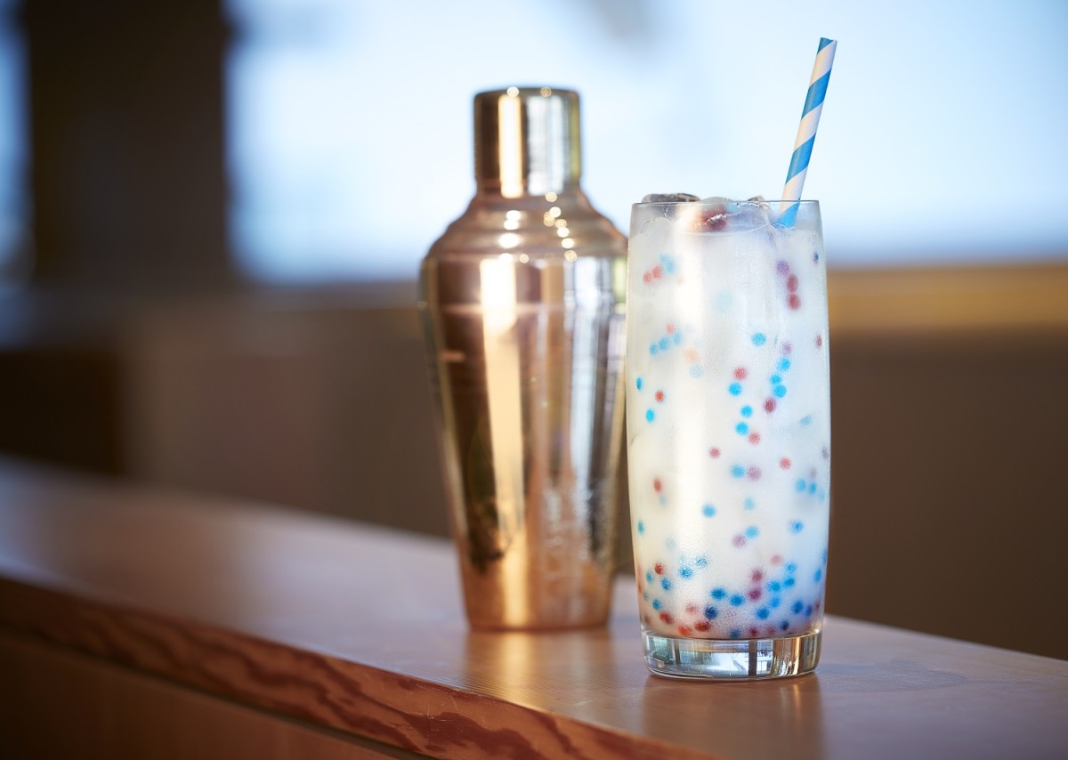 A photo of the AGO Bistro drink "Obliteration Fizz" with red and blue dots in it.