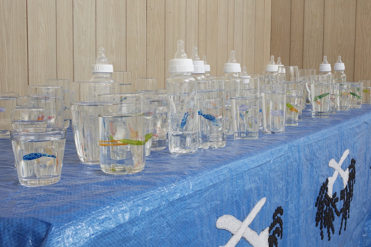 Several glasses and bottles of water on a blue table