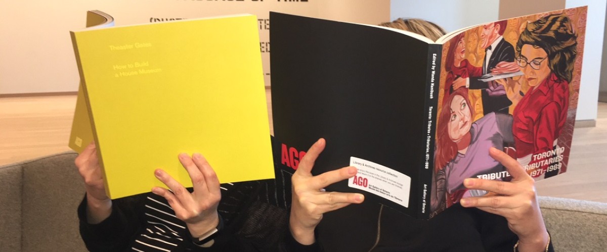 Two people with books covering their faces