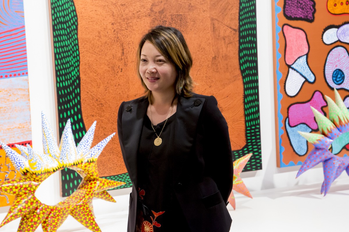 Mika Yoshitake stands in front of paintings and sculptures by Yayoi Kusama.