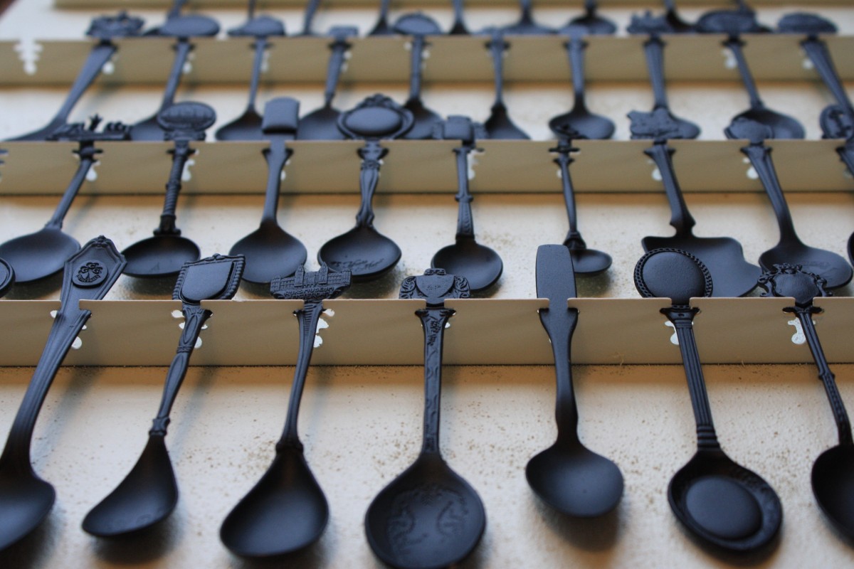Rows of ornate black spoons