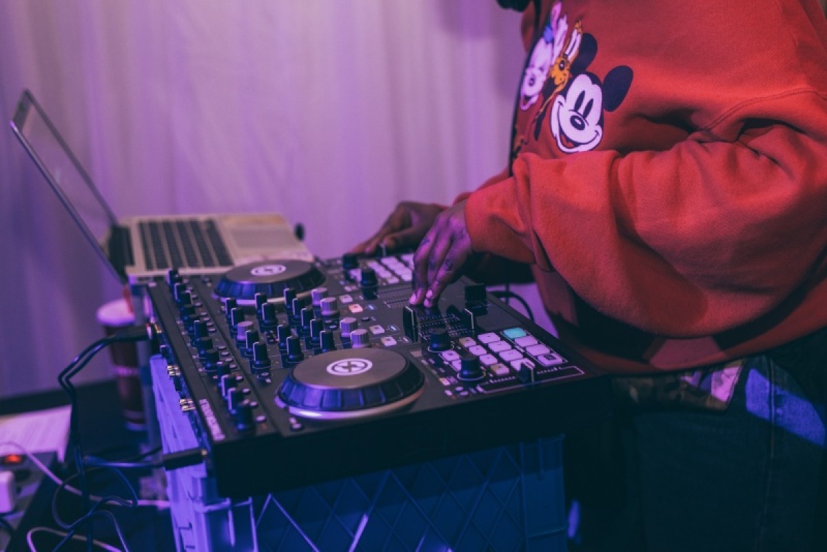 a man uses a record player and sound mixing equipment while DJ'ing