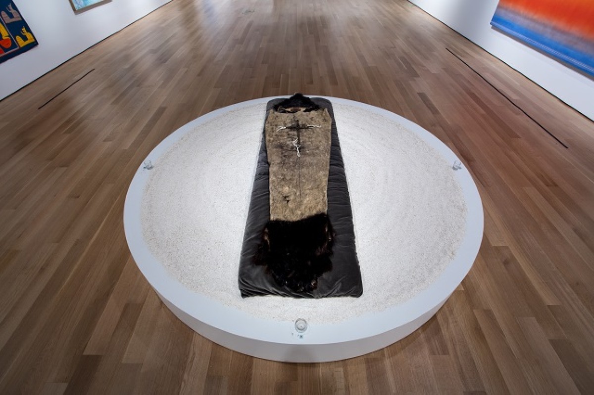 Tim Whiten. Metamorphosis, 1978-1989. Ritual vessel (completely tanned bearskin, brass bells, cotton ties), grey pillow (cotton with synthetic foam), crushed eggshells, 4 glass votive containers and candles, 4 incense tiles