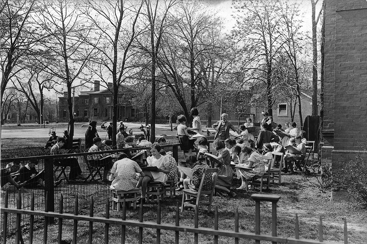 Black and white photo of Arthur Lismer conducting a children's outdoor sketching class in Grange Park