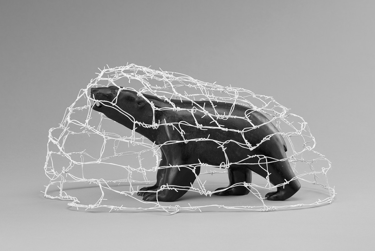 Bear Tangled in Barbed Wire. Painted barbed steel wire and stone. By Bill Nasogaluak.