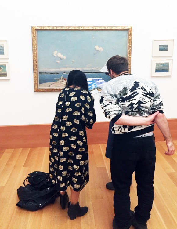 two people looking at the clouds in a painting. 