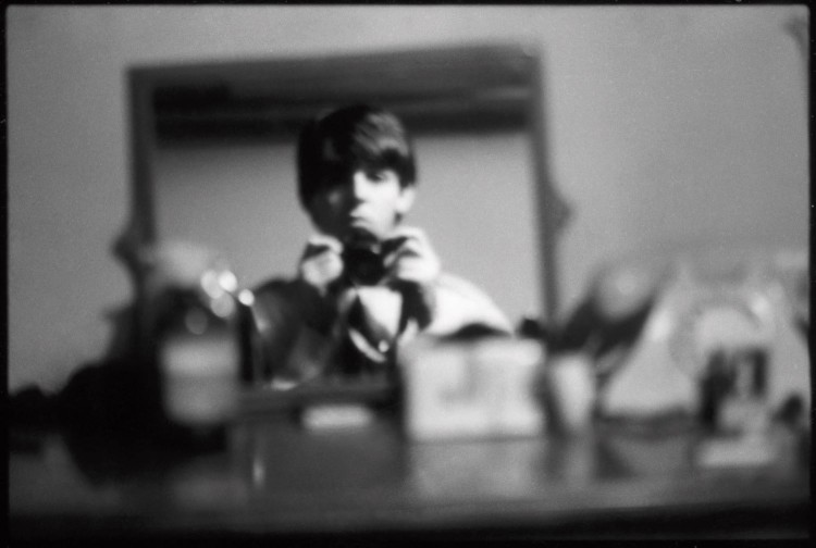 Black and white self portrait of Paul McCartney, head and shoulders reflected in mirror